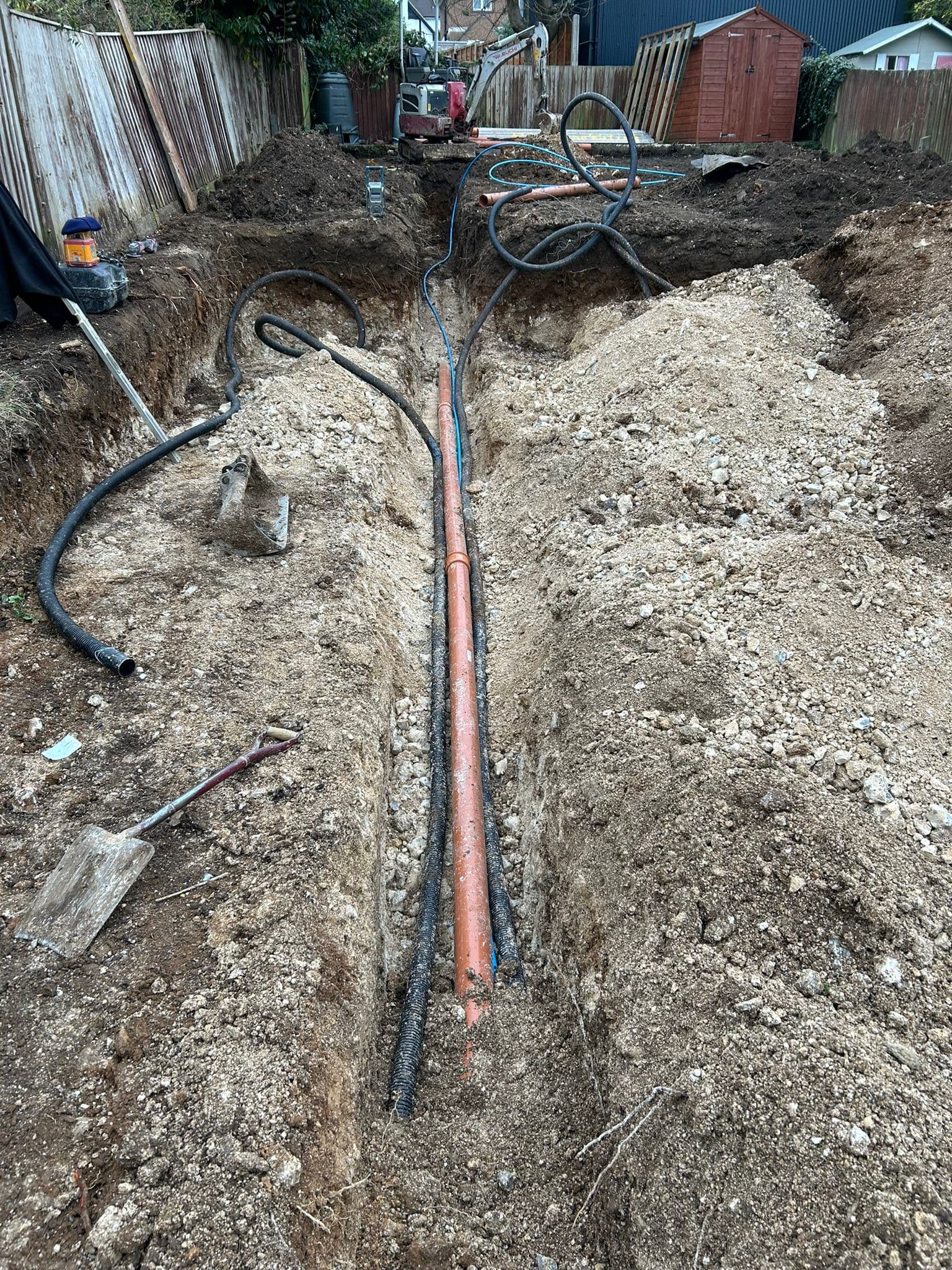 Drainage system installation with trenching and groundworks in progress
