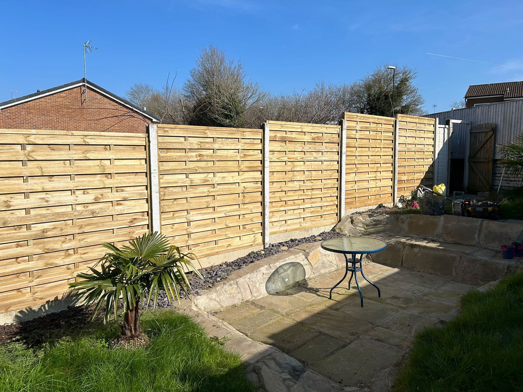 Sleeper and timber-style fencing with neat finish along a boundary